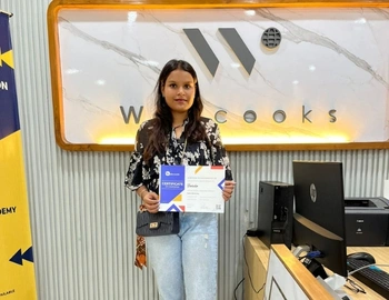 A student receives their certificate from the webcooks after completing the web designing course